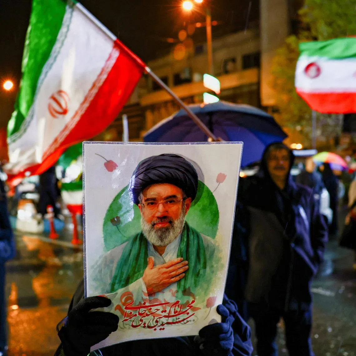 A woman holds a poster depicting Iran’s new Supreme Leader Mojtaba Khamenei during an anti-U.S. and anti-Israeli rally, amid the U.S.-Israeli conflict with Iran, in Tehran, Iran, March 26, 2026. Majid Asgaripour/WANA (West Asia News Agency) via REUTERS
