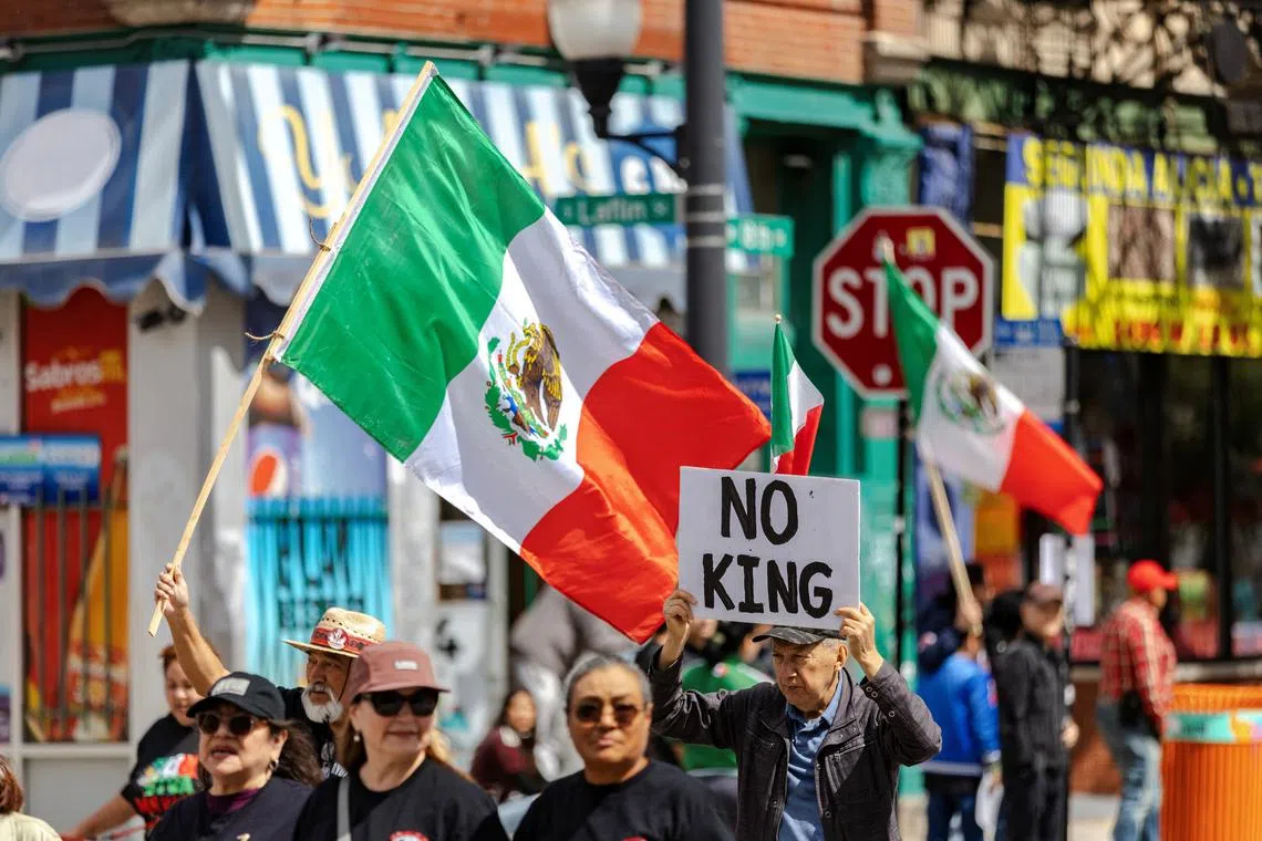 Parade participants fly Mexican flags and hold an anti-trump sign as Chicago's Mexican community proceeds with a Mexican Independence Day parade after U.S. President Donald Trump ordered increased federal law enforcement presence to assist in crime prevention, in Chicago, Illinois, U.S. September 6, 2025.  REUTERS/Jim Vondruska