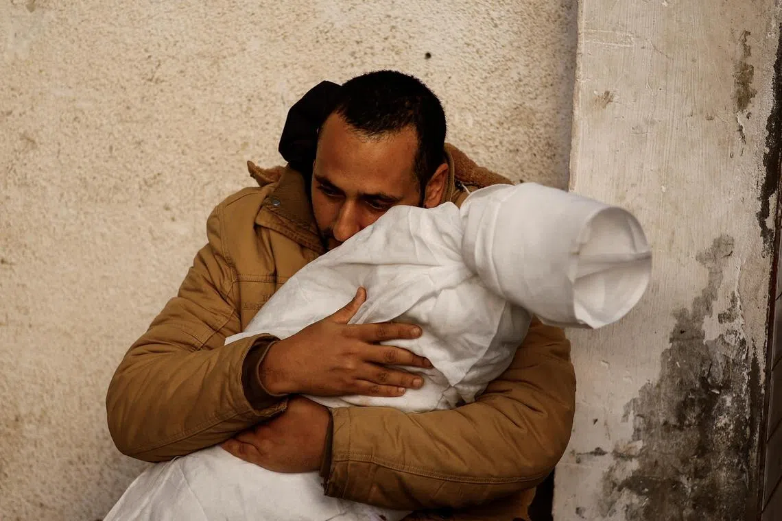 A Palestinian man holds the body of his daughter, who was killed in an Israeli air strike, at a hospital in Rafah.