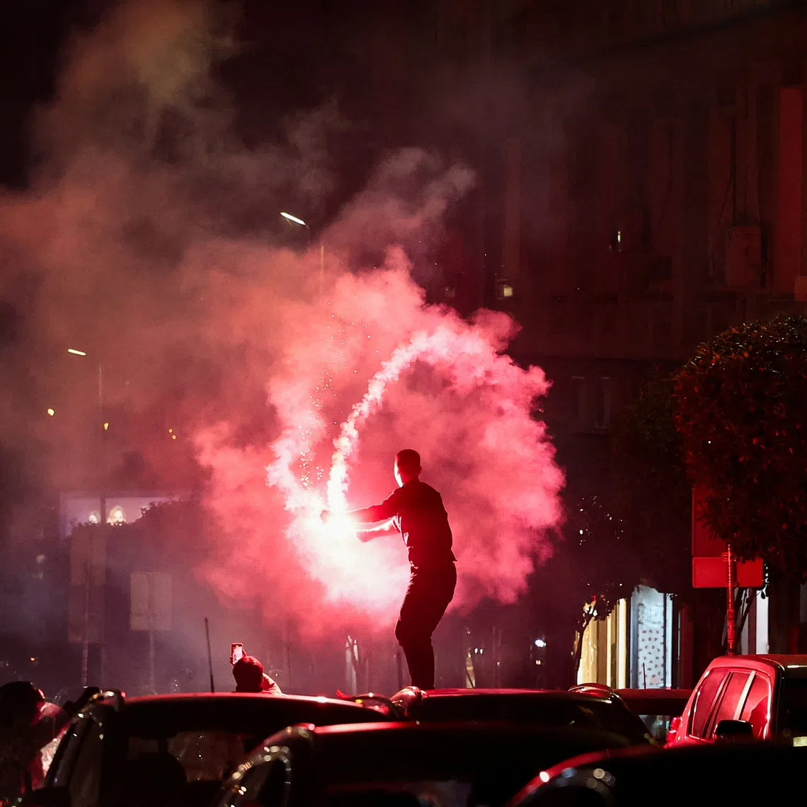 A person lights a flare as supporters of the electoral list \"Student List - Students Win\" celebrate following the first results of the parliamentary election in Belgrade, Serbia, October 25, 2026. REUTERS/Zorana Jevtic
