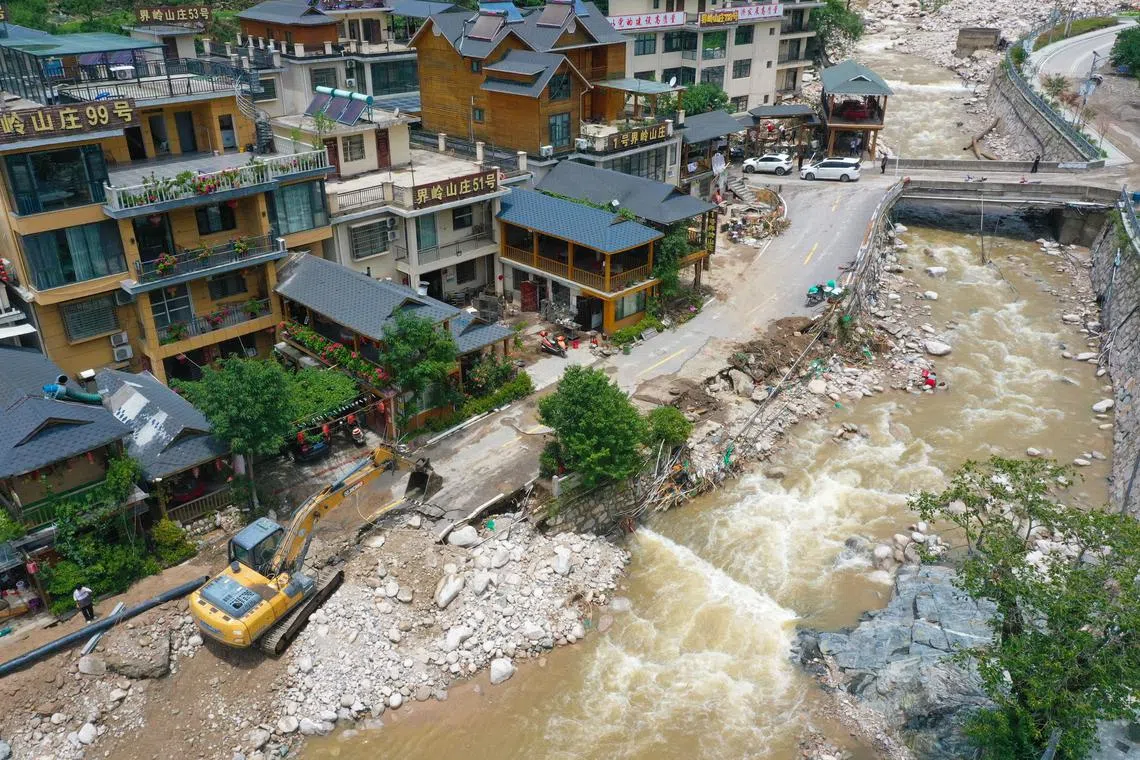 An excavator clears the road in Taiping, Henan province, on July 2.
