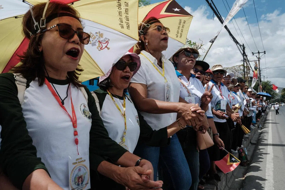 People rehearse singing along the street to welcome Pope Francis, a day before his arrival in Dili on September 8, 2024. (Photo by Yasuyoshi CHIBA / AFP)