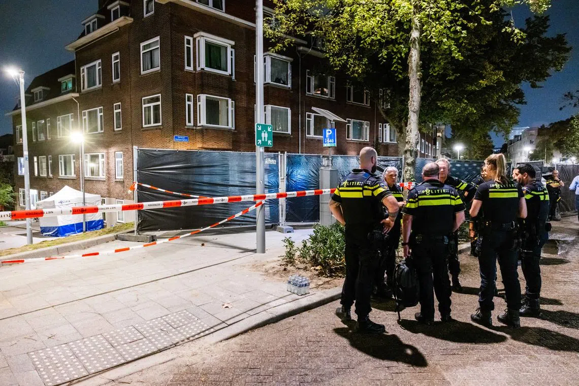Police and fire brigade personnel investigating the building where the suspect shot two victims, in Rotterdam, tjhe Netherlands, on Sept 28.
