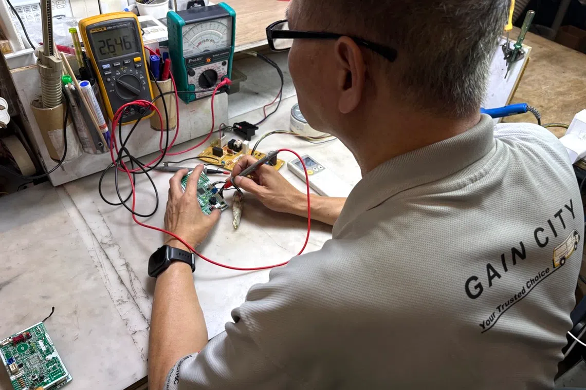 Gain City’s repair specialists checking whether faulty appliances can be given a second life. It is running a free repair clinic for eligible electrical appliances in October at its Sungei Kadut megastore.