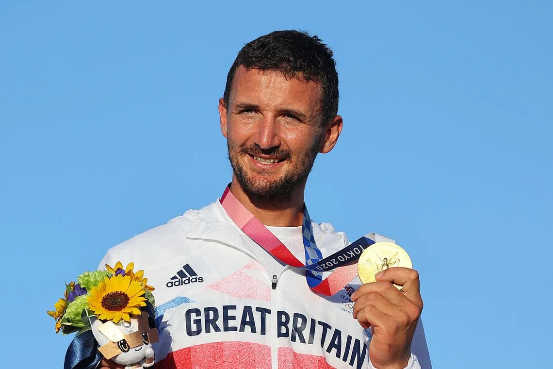 FILE PHOTO: Tokyo 2020 Olympics - Sailing - Men's Finn - Medal Ceremony - Enoshima Yacht Harbour - Tokyo, Japan - August 3, 2021. Gold medallist Giles Scott of Britain celebrates on the podium. REUTERS/Carlos Barria/File Photo