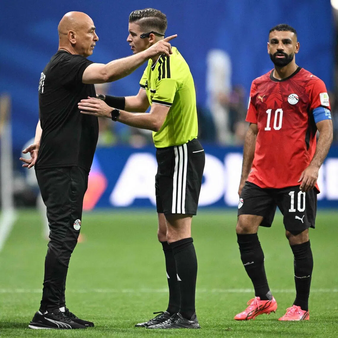 Egypt’s head coach Hossam Hassan (in black) speaks with French referee Francois Letexier during the 2026 World Cup round of 16 football match in Atlanta.