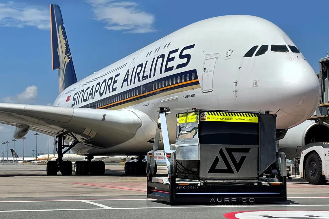 yfchangi06 - An Auto-Dolly autonomous baggage vehicle pictured next to a Singapore Airlines Airbus A380 plane on the tarmac at Changi Airport. The driverless vehicle is currently being trialled at the airport to transport baggage and cargo.

Credit: Aurrigo