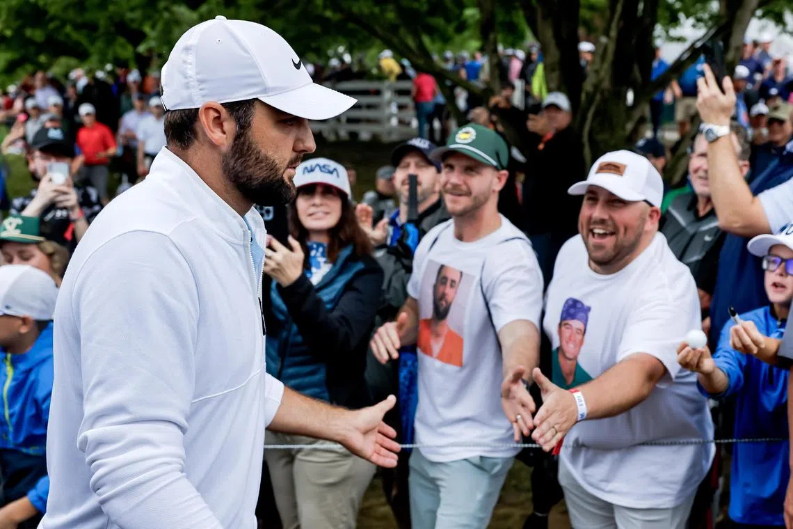 epa11348893 Scottie Scheffler (L) of the US walks off the ninth green through a throng of fans, including Cole Turner (C) after finishing his second round of the 2024 PGA Championship golf tournament at the Valhalla Golf Club in Louisville, Kentucky, USA, 17 May 2024. Earlier in the day Scheffler was arrested by police officers after an incident at the entrance to the golf course but was released without bail.  EPA-EFE/ERIK S. LESSER