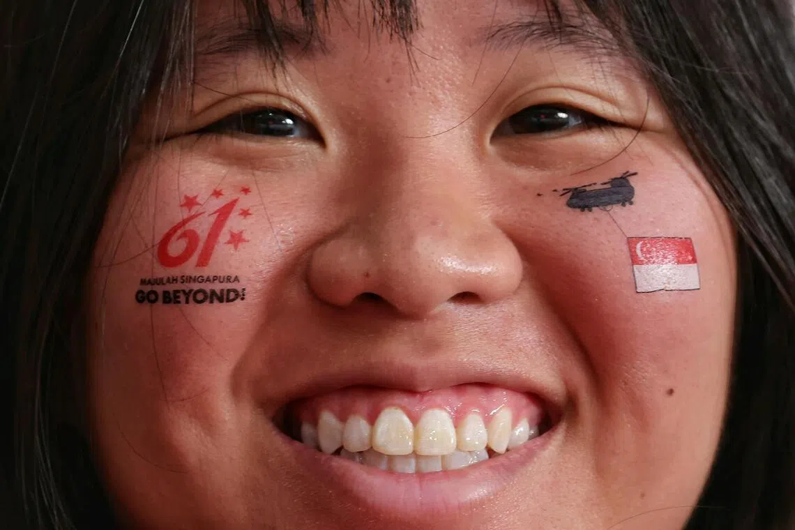 Undergraduate Tegan Neow, 19, sporting temporary face tattoos during National Day Parade 2026 at the National Stadium on Aug 9, 2026. ST PHOTO: KEVIN LIM
