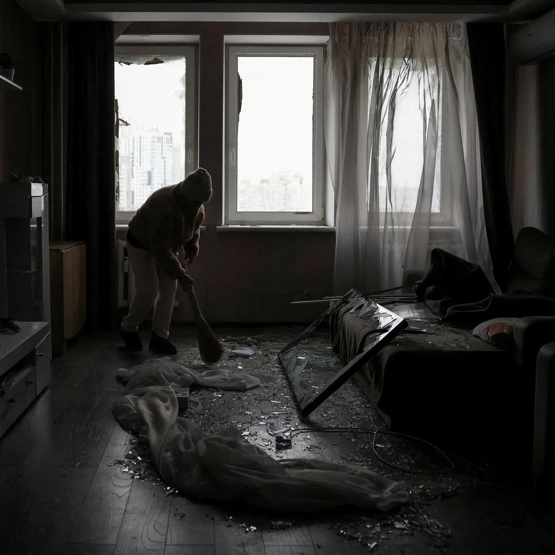 FILE PHOTO: A resident cleans her flat in an apartment building damaged by a Russian drone strike, amid Russia's attack on Ukraine, in Kyiv, Ukraine January 9, 2026. REUTERS/Anatolii Stepanov/File Photo