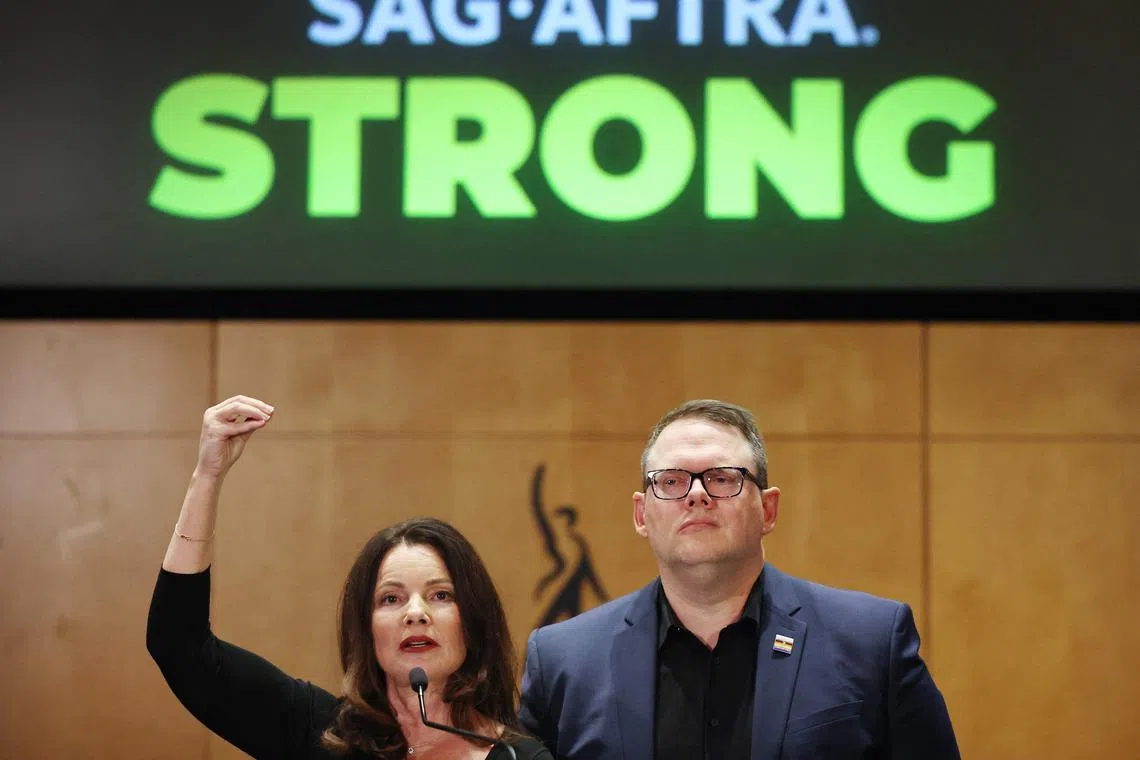 SAG-AFTRA President Fran Drescher (L) speaks as SAG-AFTRA National Executive Director Duncan Crabtree-Ireland looks on at a press conference discussing their strike-ending deal with the Hollywood studios.