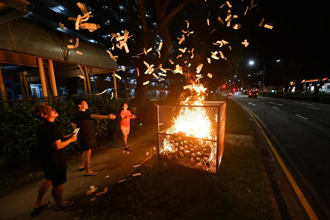 ST20220728-202272561220-Lim Yaohui-pixghost/
(From left) Mr Richard Teo, 37, a private hire driver; Mr Wong Wei Sen, 19, Private diploma student member and Madam Kang Hwee Leng, 57, Fruit and flower seller; burning joss paper near 105 Lorong 1 Toa Payoh on July 29, 2022.
Mr Richard Teo, 37, a private hire driver, is in charge of the Hup Zhong Hungry Ghost Festival Committee. There are around 55 members in the committee who contribute membership fees. As the main organiser, he helped conduct prayer sessions, organise dinner with auction and even getai shows every year during Hungry Ghost Festival. This is the first time they are doing this after missing it the last two years because of the pandemic and will only organise dinner next year. The prayer session was held at 105 Lorong 1 Toa Payoh, because he used to stay there and he has since moved to Lorong 7 more than 10 years ago. It costs $120 to rent the burner and about $500 to buy the joss paper and offerings.
(ST PHOTO: LIM YAOHUI)