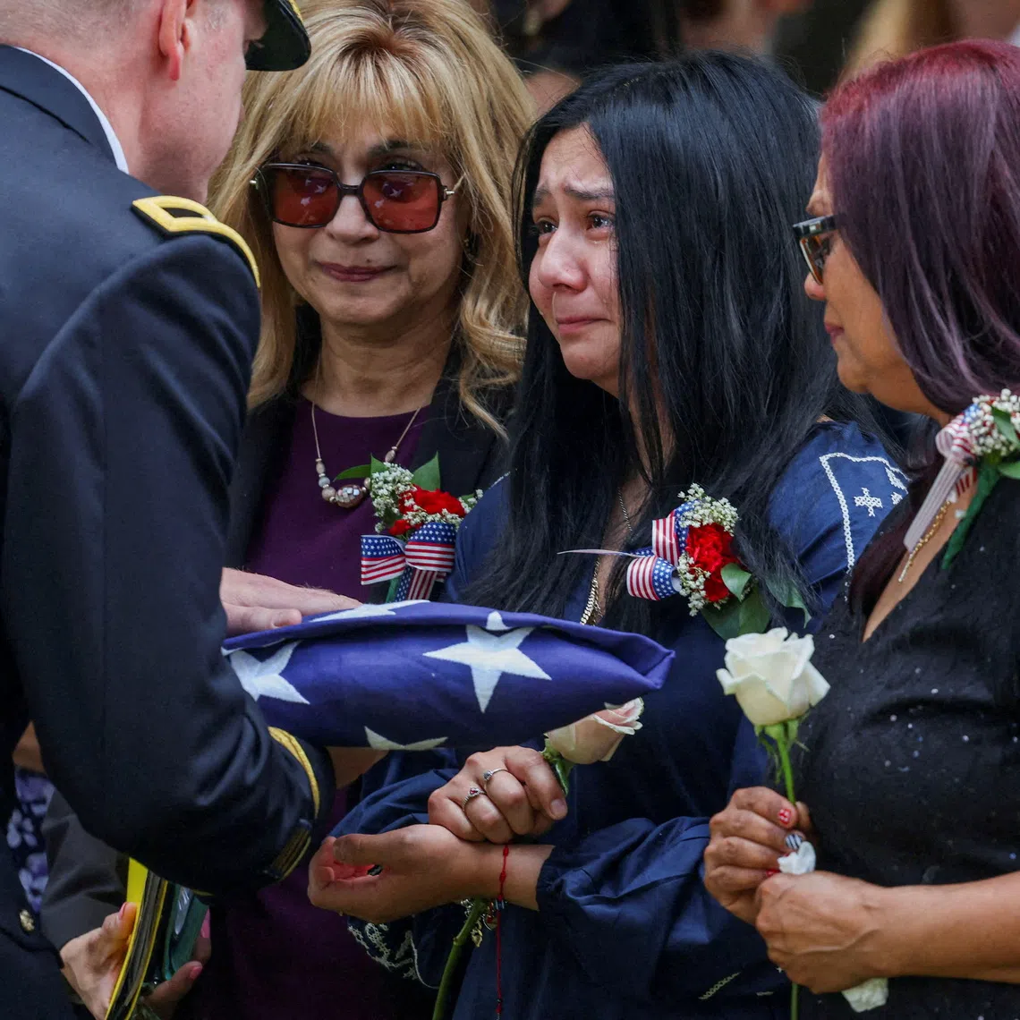 Family members are presented with a flag on July 31, during a burial service for US soldier Angel S. Rampersad, who was killed in an attack on Muwaffaq Salti Air Base in Jordan. Eighteen US service members have been killed in the conflict and more than 750 wounded.