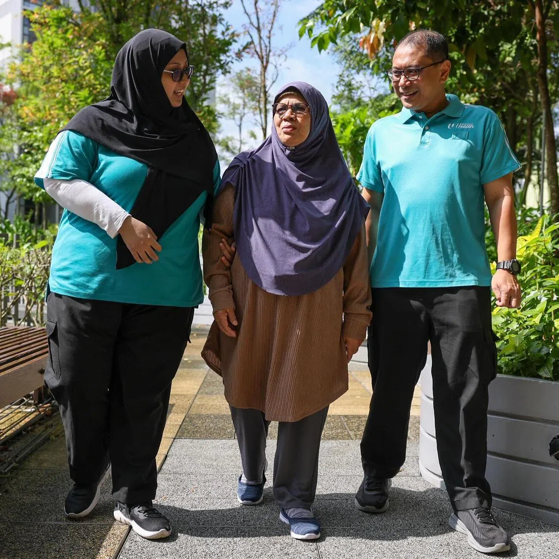ST20260226_202671200588/Jasel Poh/sfcip01

Photo of Mdm Maria Binte Hadi, 72, (middle) walking with NTUC health staff Zainai Bin Mohamed Sharif (right) and Kamaria Binte Md Yassin at Kampung Admiralty NTUC Health Centre Rehabilitation and Wellness Centre on Feb 26, 2026.