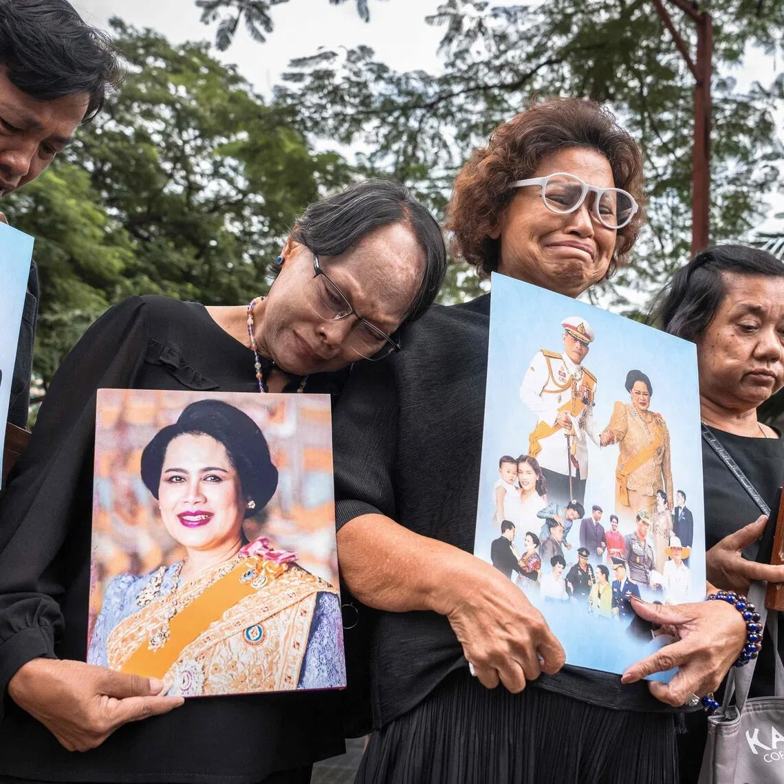Mourners hold portraits of Thailand's former queen Sirikit on Oct 25 as they gather in front of Chulalongkorn Hospital, where she died. Her body will lie in state for one year at Bangkok's Grand Palace before being cremated.