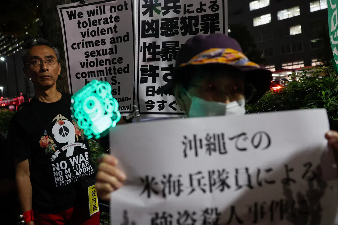 Demonstrators hold placards during a protest outside Foreign Ministry building following the killing of a Japanese woman in Okinawa, for which a US Marine is a suspect, in Tokyo, Japan, October 8, 2026. REUTERS/Kim Kyung-Hoon