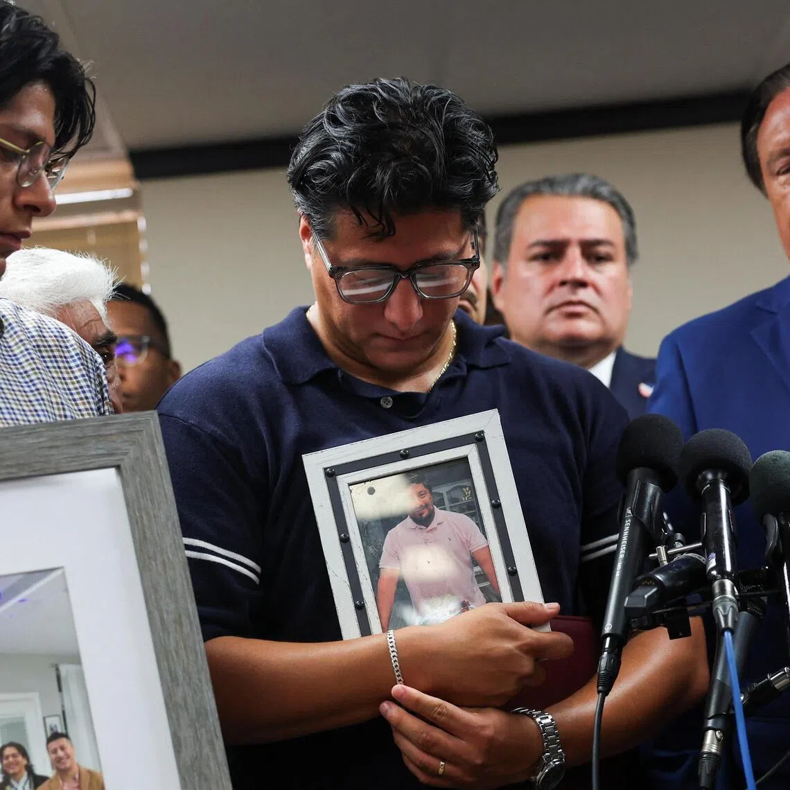 Ronaldo Salgado holds a picture of his father Lorenzo Salgado Araujo, who was fatally shot by an ICE agent, during a news conference in Houston, on July 8.