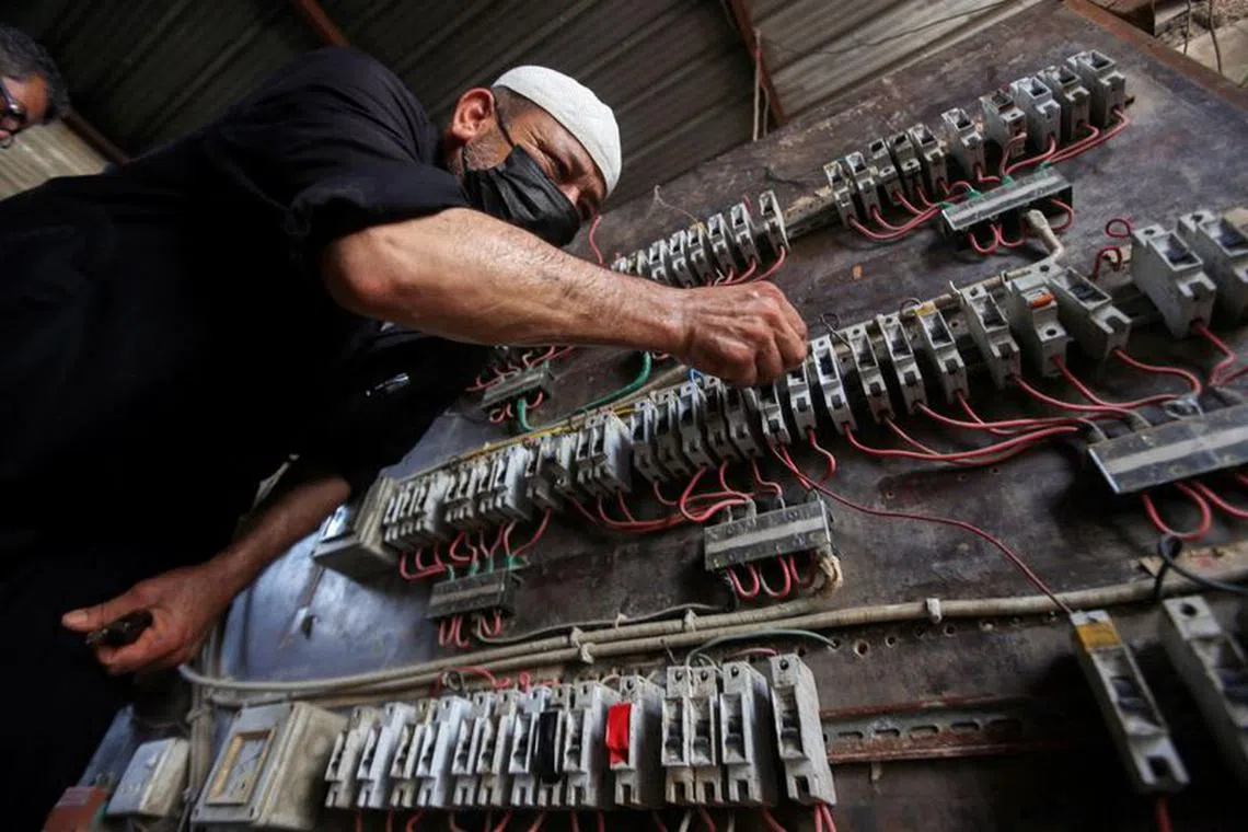 FILE PHOTO: A man works on an electrical generator board during power outages in Basra, Iraq August 21, 2021. Picture taken August 21, 2021. REUTERS/Essam al-Sudani/File Photo