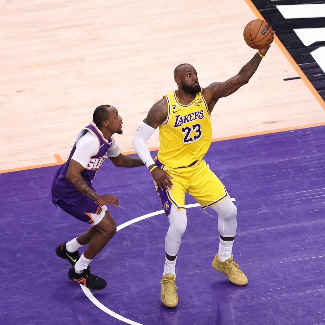 LeBron James of the Los Angeles Lakers catches a pass over Jamaree Bouyea of the Phoenix Suns during the second half at Mortgage Matchup Center.