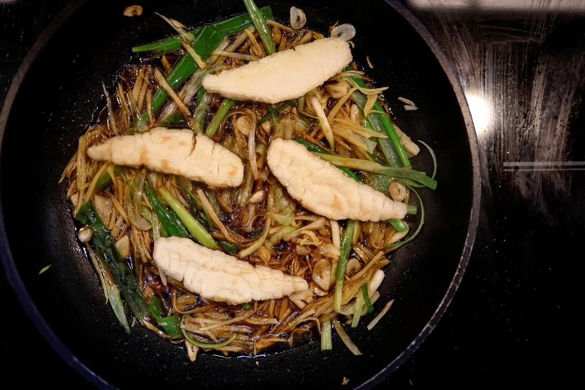 A dish containing pieces of 3D-printed cultivated grouper fish is prepared for a tasting at the offices of Steakholder Foods in Rehovot, Israel, April 23, 2023. REUTERS/Amir Cohen