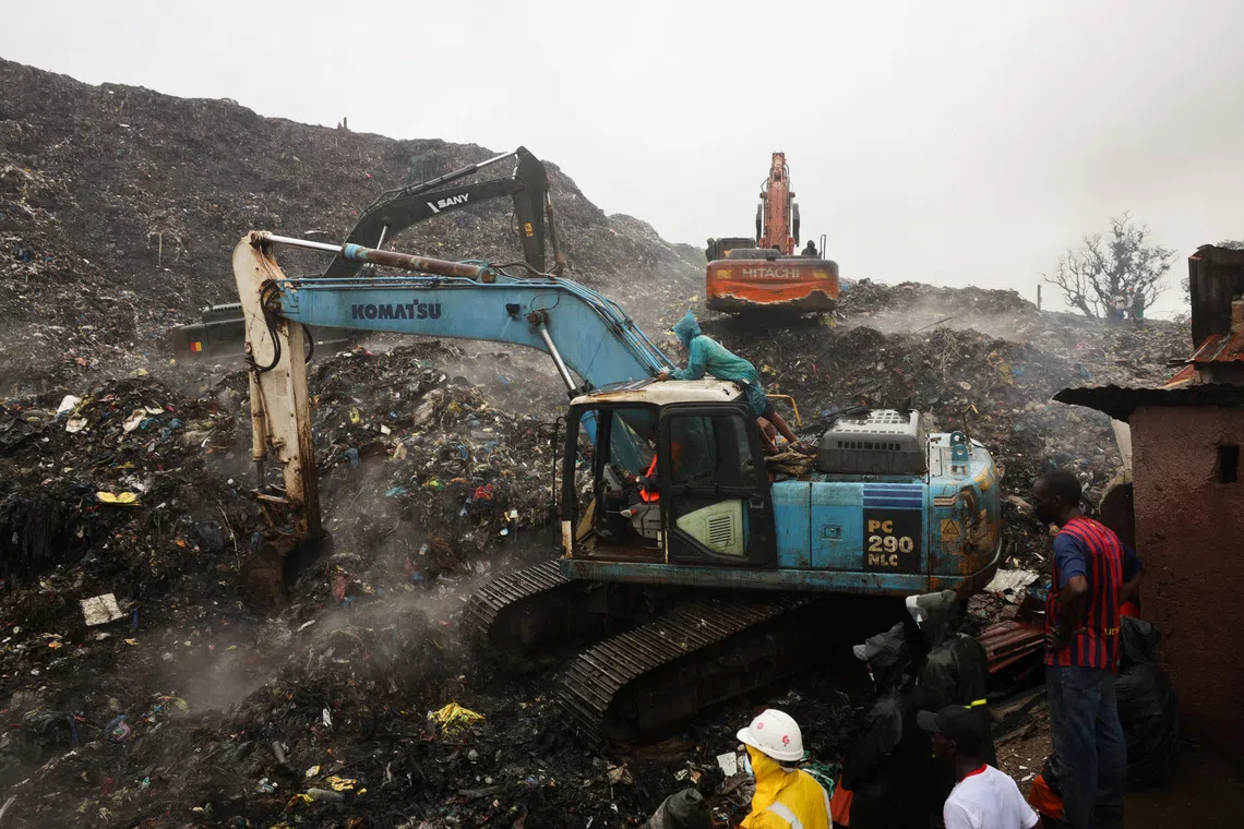 Rescue workers search through debris at the incident site in the Dar es Salam area in Conakry, Guinea, on Aug 23.