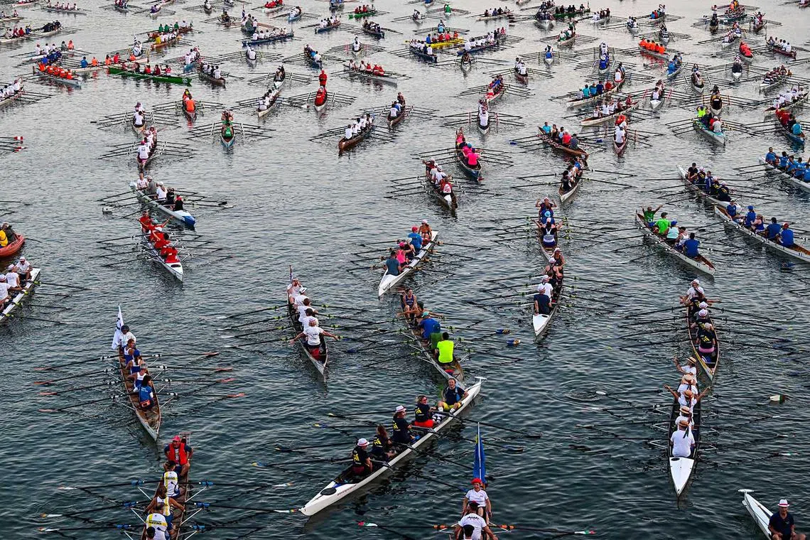 Rowers scull along the River Seine towards the Ile de la Cité, as they participate in the annual 'La Traversee de Paris en Aviron' rowing event, that brings together more than 1,000 rowers and 230 boats in Paris, on Sept 10.