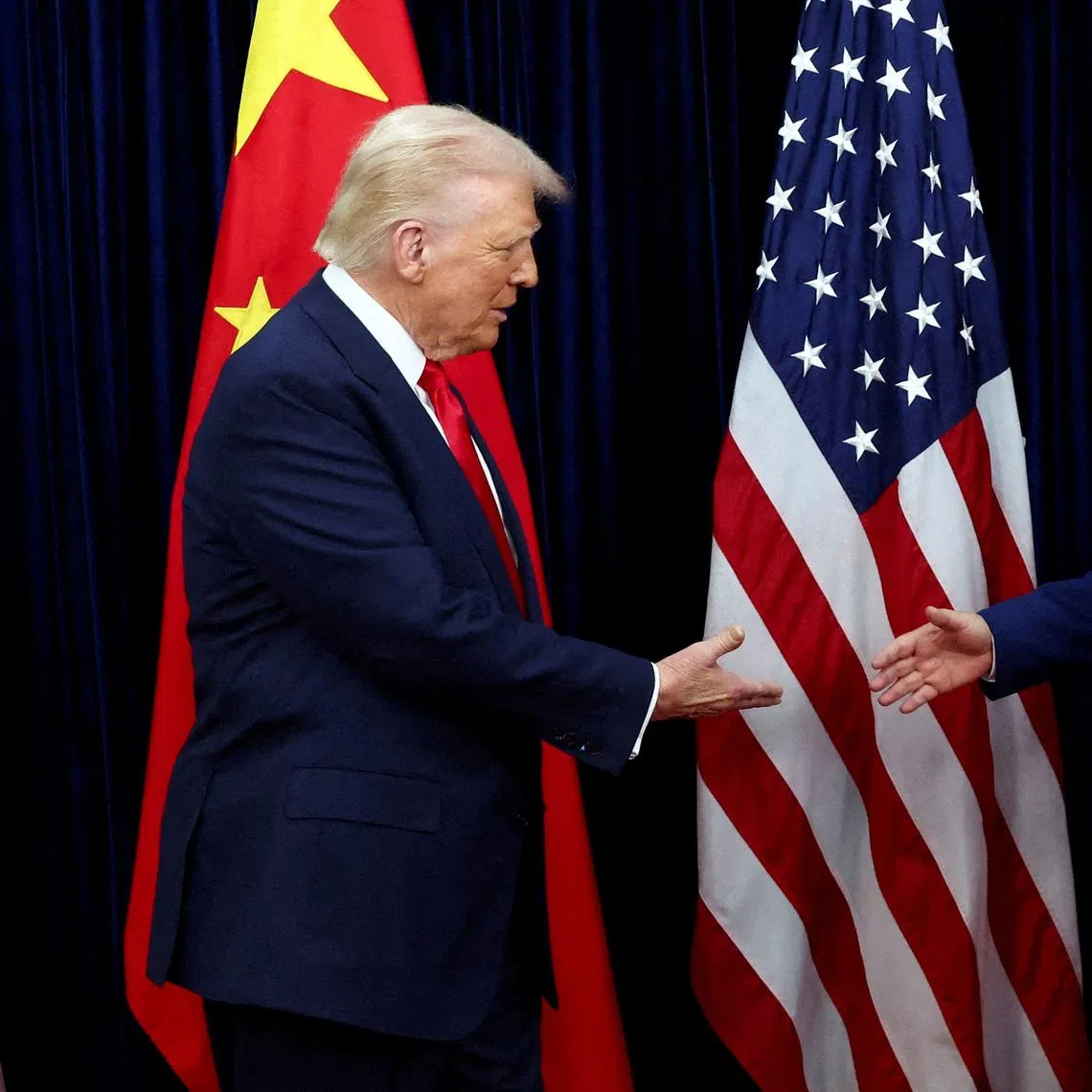 FILE PHOTO: U.S. President Donald Trump shakes hands with Chinese President Xi Jinping as they hold a bilateral meeting at Gimhae International Airport, on the sidelines of the Asia-Pacific Economic Cooperation (APEC) summit, in Busan, South Korea, October 30, 2025. REUTERS/Evelyn Hockstein//File Photo