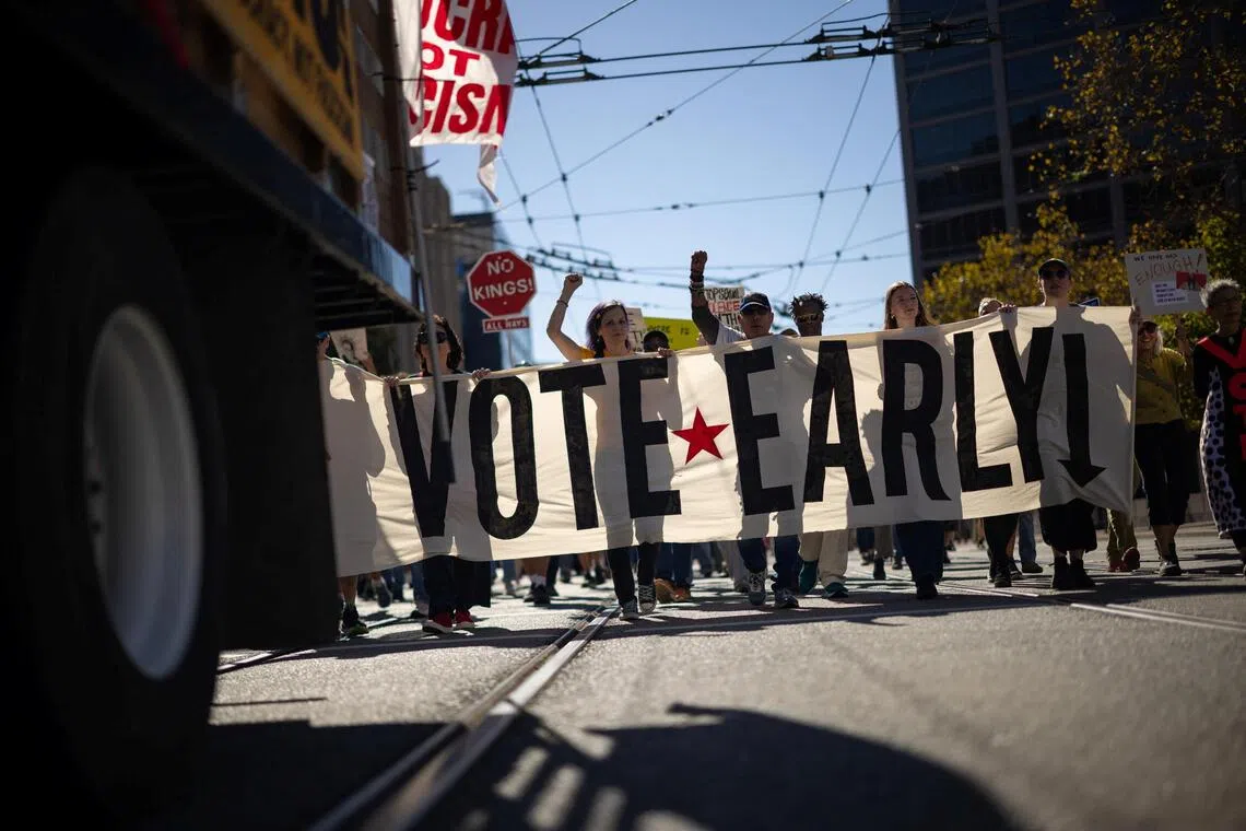 People holding a banner at a ‘No Kings: Vote Early’ protest in San Francisco on Oct 17.