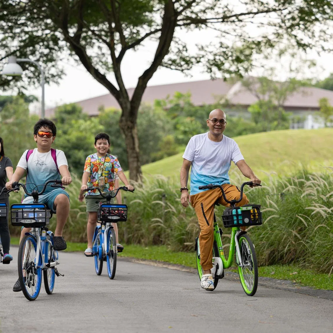 ST20240714_202460991046/elbike27/Brian Teo/Esther Loi/ Mr Daren Oliveiro, 43, Hawker, riding rental bikes with his wife Vivian Liem, 38, and two sons Davian Oliveiro, 11, and Arius Oliveiro, 9, Lakeside Primary School students, at Jurong Lake Garden on July 14, 2024. The convenience of bike-sharing bikes allows Daren to use cycling as a way to bond with his family. ST PHOTO: BRIAN TEO.