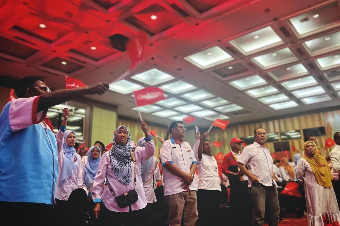 Pakatan Harapan delegates waving their flags as PM Anwar Ibrahim takes the stage during the PH Convention at the Persada Johor International Convention centre in Johor Bahru on May 17.