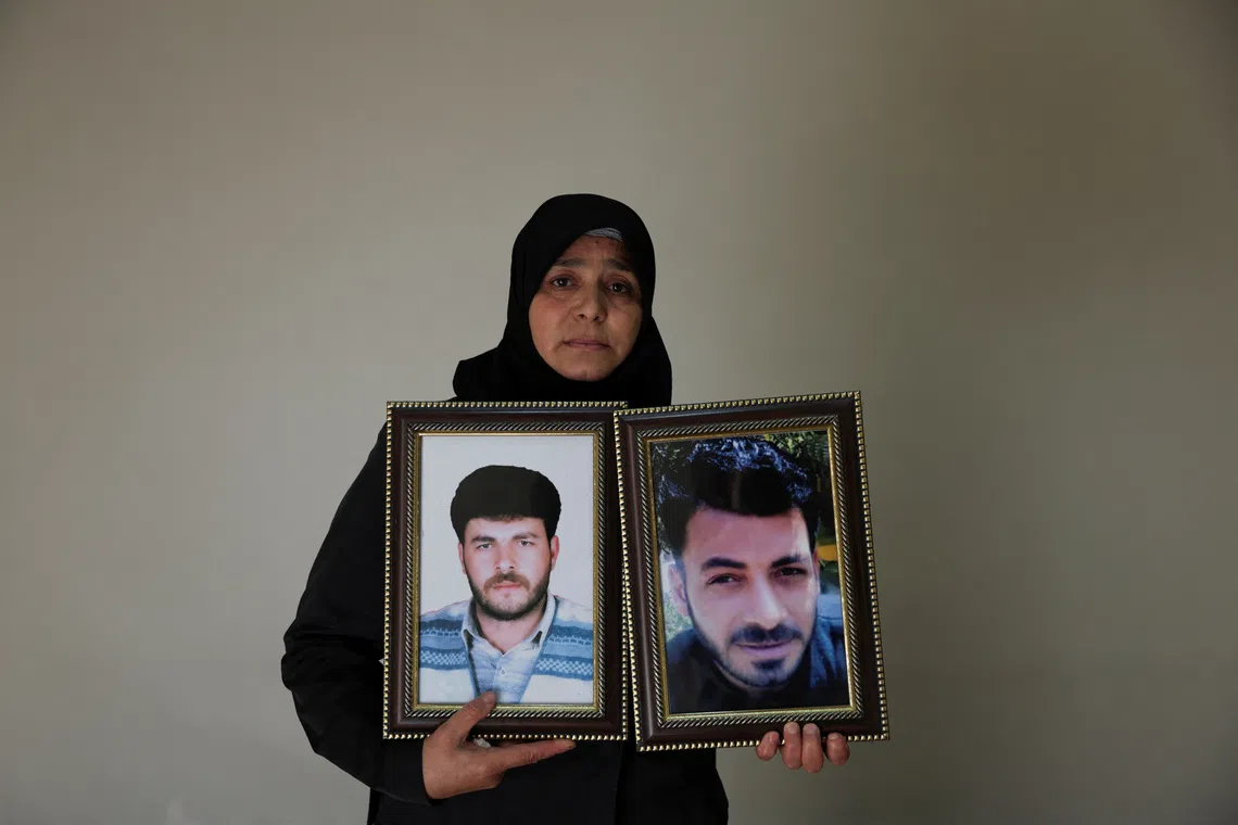 Amina Beqai, holding a photo of her husband and brother, who went missing after they were arrested by security forces under the rule of ousted President Bashar al-Assad, in Damascus, Syria, November 23, 2025. REUTERS/Khalil Ashawi