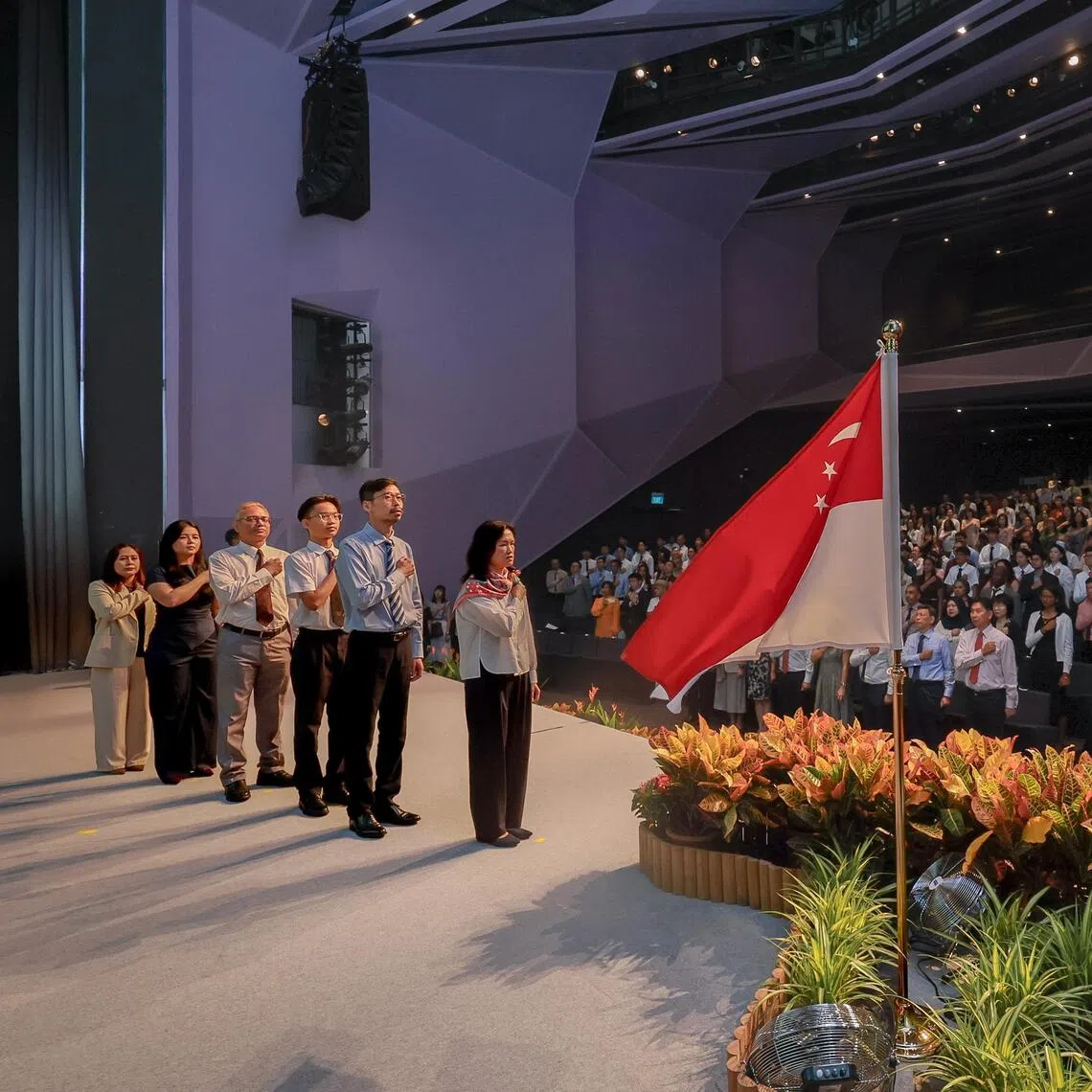 New Singapore citizens on stage lead the recitation of the National Pledge during the National Citizenship Ceremony at SUTD on Aug 15.