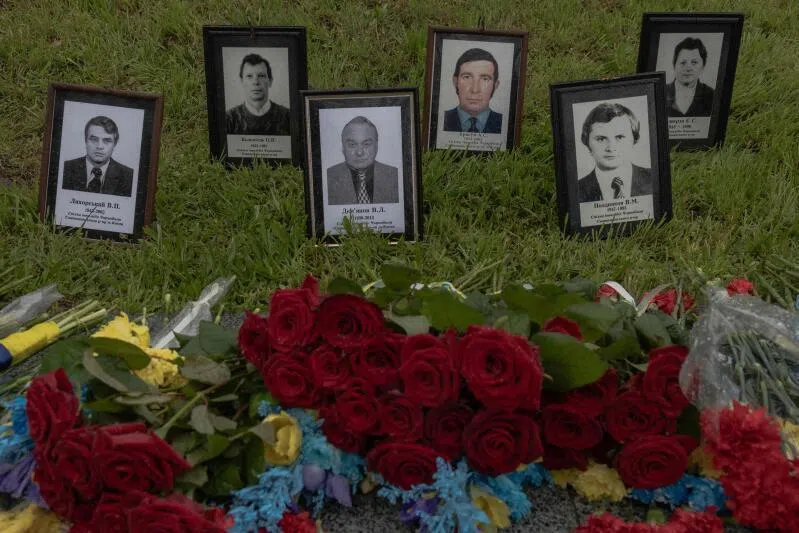 Portraits displayed next to flowers at a memorial for the victims of Chernobyl, on the 40th anniversary of the explosion at the nuclear power plant, in Kyiv on April 26, 2026.