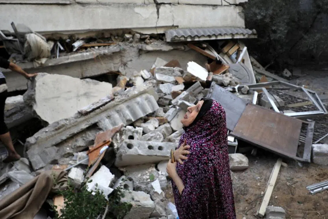 A Palestinian woman reacts at the site of an Israeli strike on a residential building in Gaza City October 25, 2023. REUTERS/Yasser Qudih