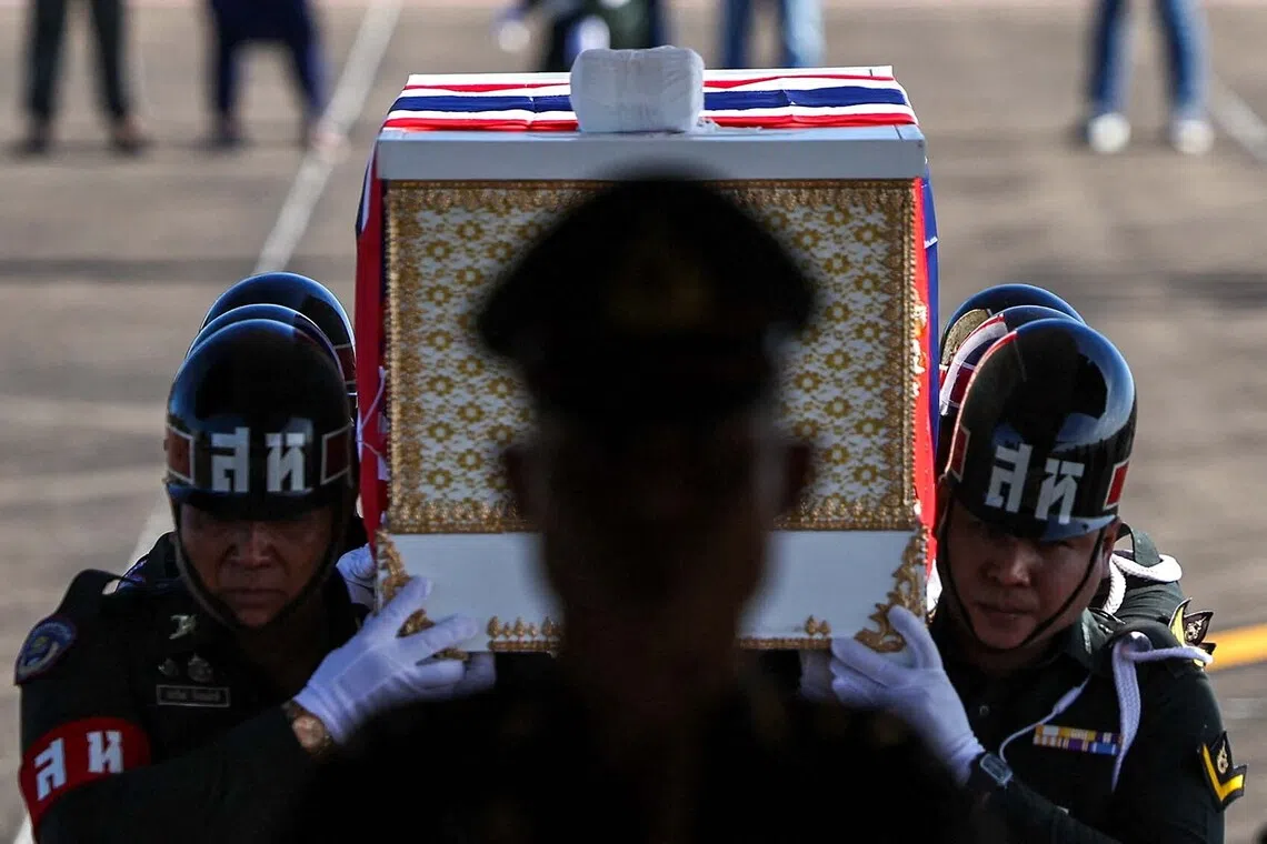 Military personnel carry the coffin of Private Kritdikorn Sroiraya, covered by the Thai national flag, during a procession ceremony to transport bodies to their home town, at a military airport, following deadly clashes between Thailand and Cambodia along a disputed border area, in Ubon Ratchathani province, Thailand, December 14, 2025. REUTERS/Athit Perawongmetha  TPX IMAGES OF THE DAY