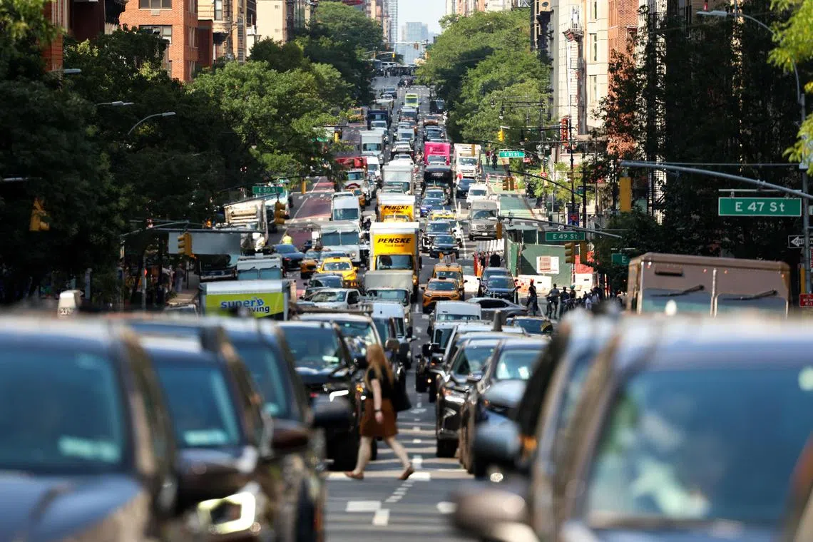 Cars and pedestrians move along the 2nd Avenue in the Manhattan borough of New York City on July 29, 2025. The US Environmental Protection Agency (EPA) on July 29, 2025, issued a proposal to rescind a foundational scientific finding that underpins the federal government's authority to limit greenhouse gas emissions from motor vehicles and, more broadly, to address climate change. (Photo by CHARLY TRIBALLEAU / AFP)
