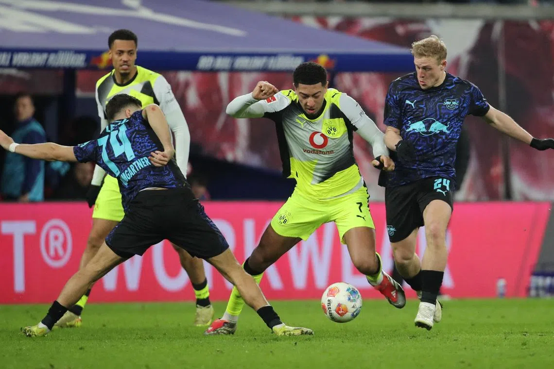 Soccer Football - Bundesliga - RB Leipzig v Borussia Dortmund - Red Bull Arena, Leipzig, Germany - February 21, 2026 Borussia Dortmund's Jobe Bellingham in action with RB Leipzig's Christoph Baumgartner and Xaver Schlager REUTERS/Karina Hessland