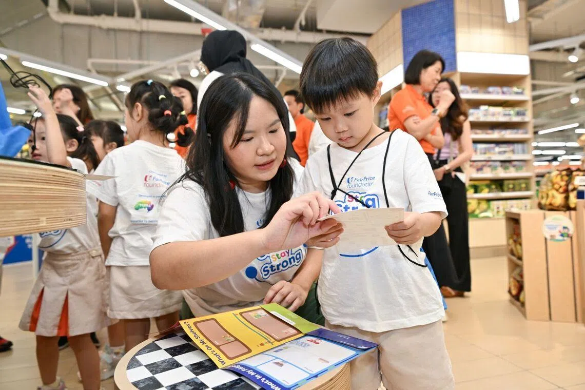 Teacher and child participating in FairPrice supermarket’s Food Finder Adventure, looking at a piece of paper