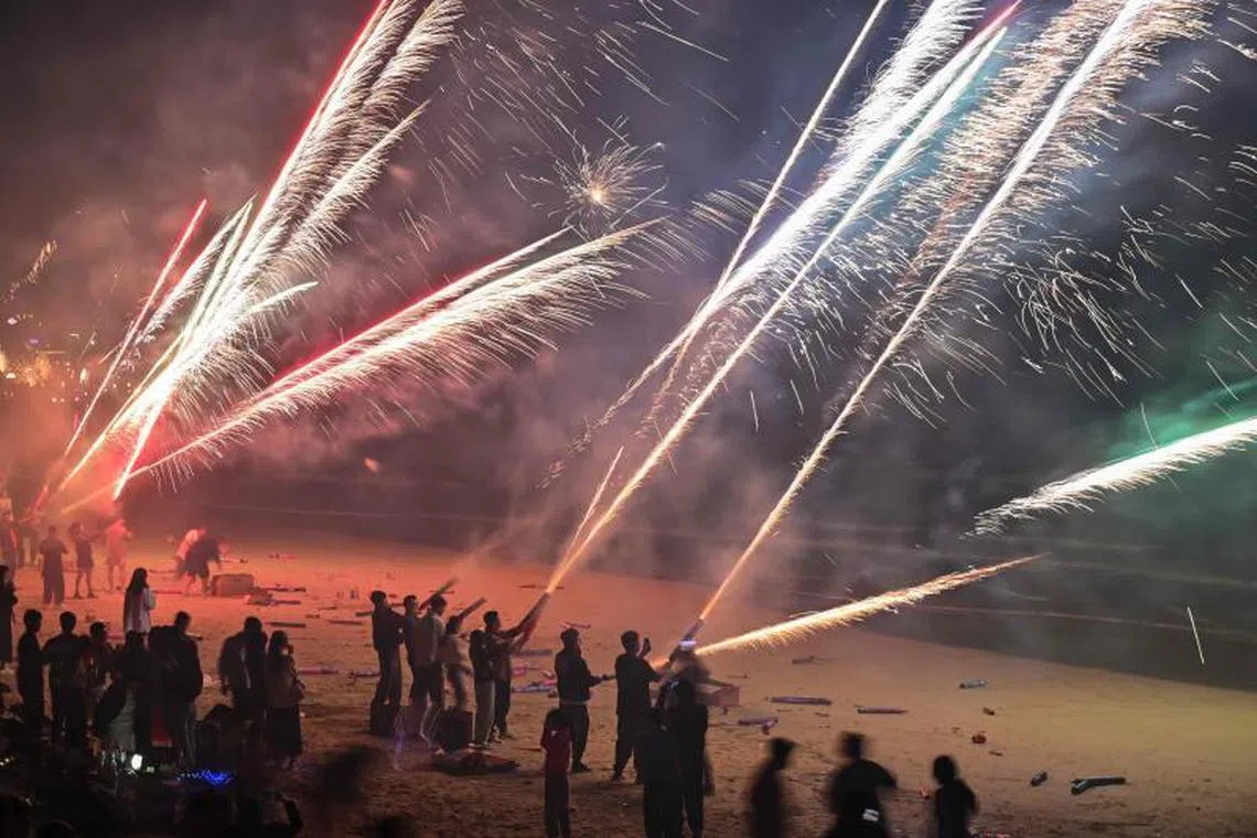 People celebrate the new year with fireworks on a beach in Houhai, in Sanya in China's southern Hainan province on January 1, 2023. PHOTO : AFP