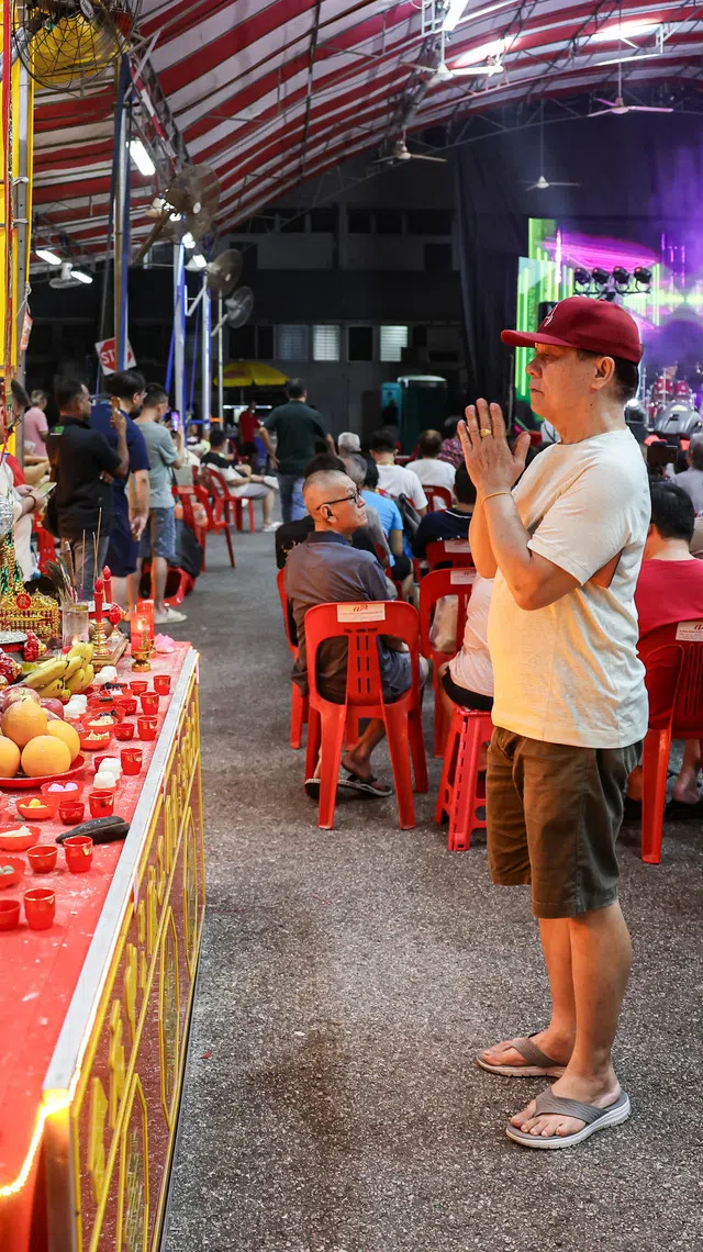 A member of the audience praying at a hungry ghost festival getai show at Toa Payoh Industrial Park on Aug 20.