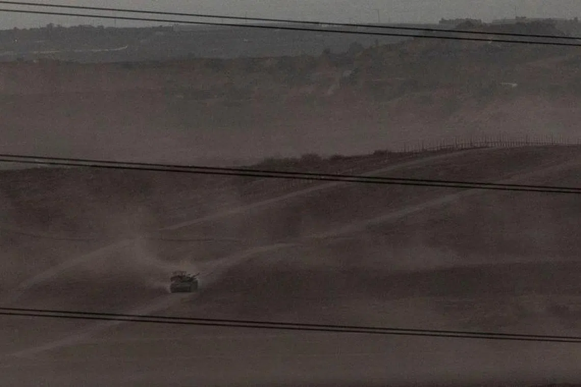 FILE PHOTO: Israeli troops manoeuvre near the Israel-Gaza border, as seen from the southern Israel, November 9, 2023. REUTERS/Evelyn Hockstein/File Photo