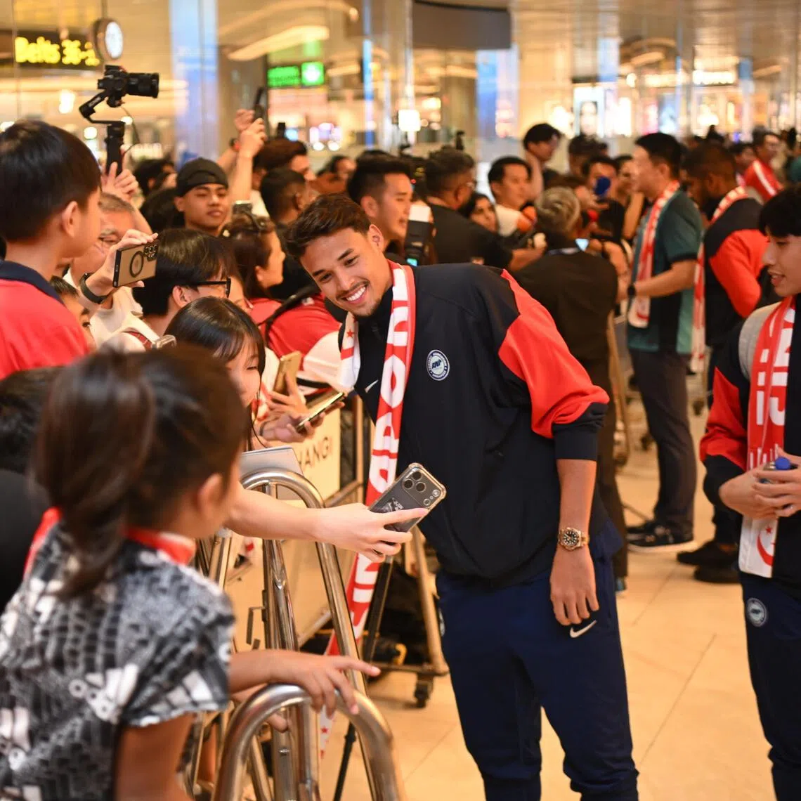 Ilhan Fandi interacting with fans at Changi Airport on Nov 19 after returning with the Singapore team from Hong Kong.