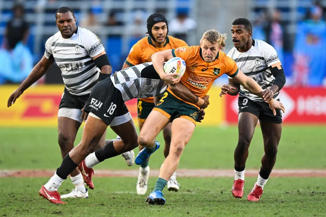 Australia’s Stuart Dunbar being tackled by Fiji’s Ponepati Loganimasi and Pilipo Bukayaro during the third-place play-off at the Los Angeles 2023 World Rugby Sevens. 