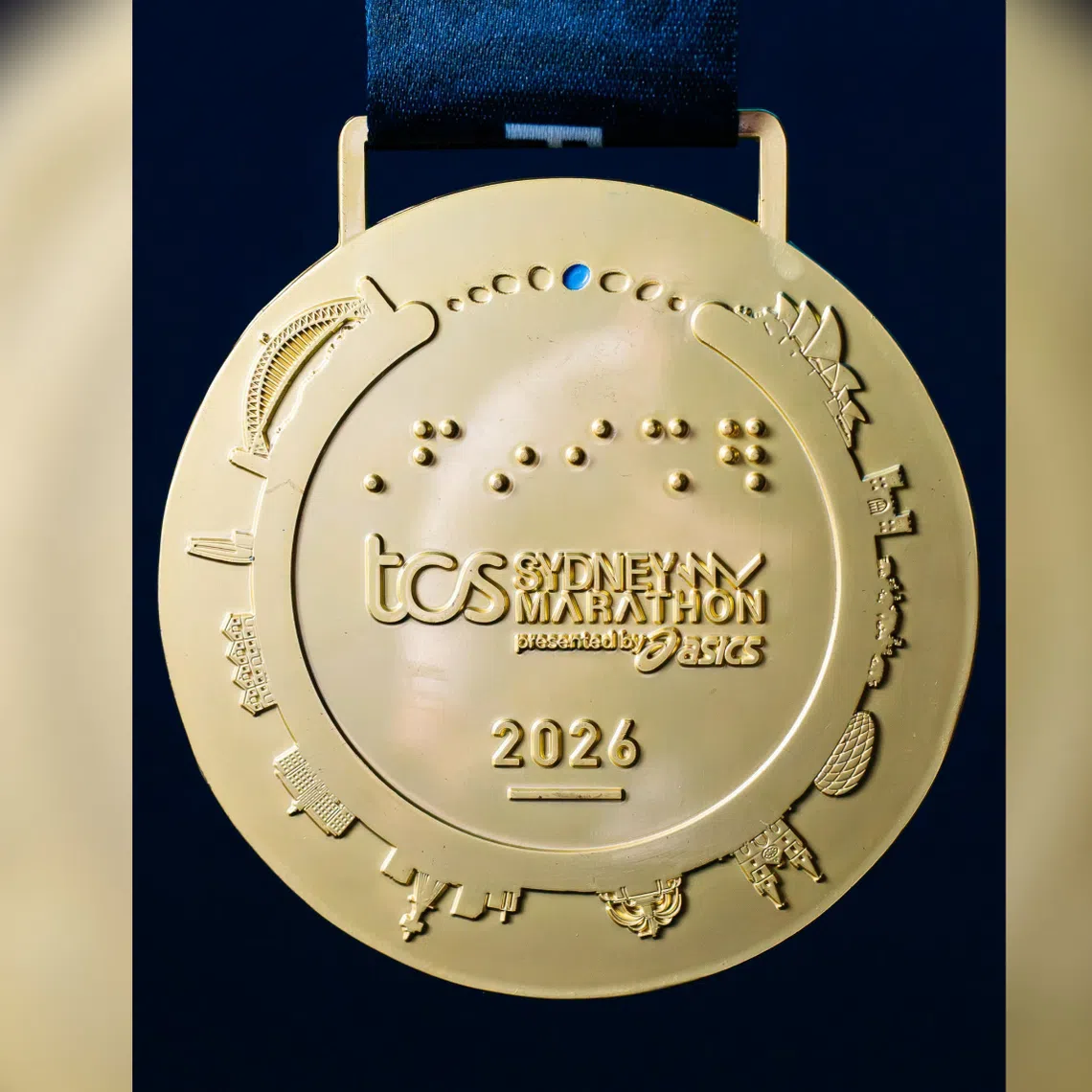 Munich’s Allianz Arena’s shape and diamond-patterned exterior seem to be reproduced in the medal instead of the flatter features of Allianz Stadium in Sydney.