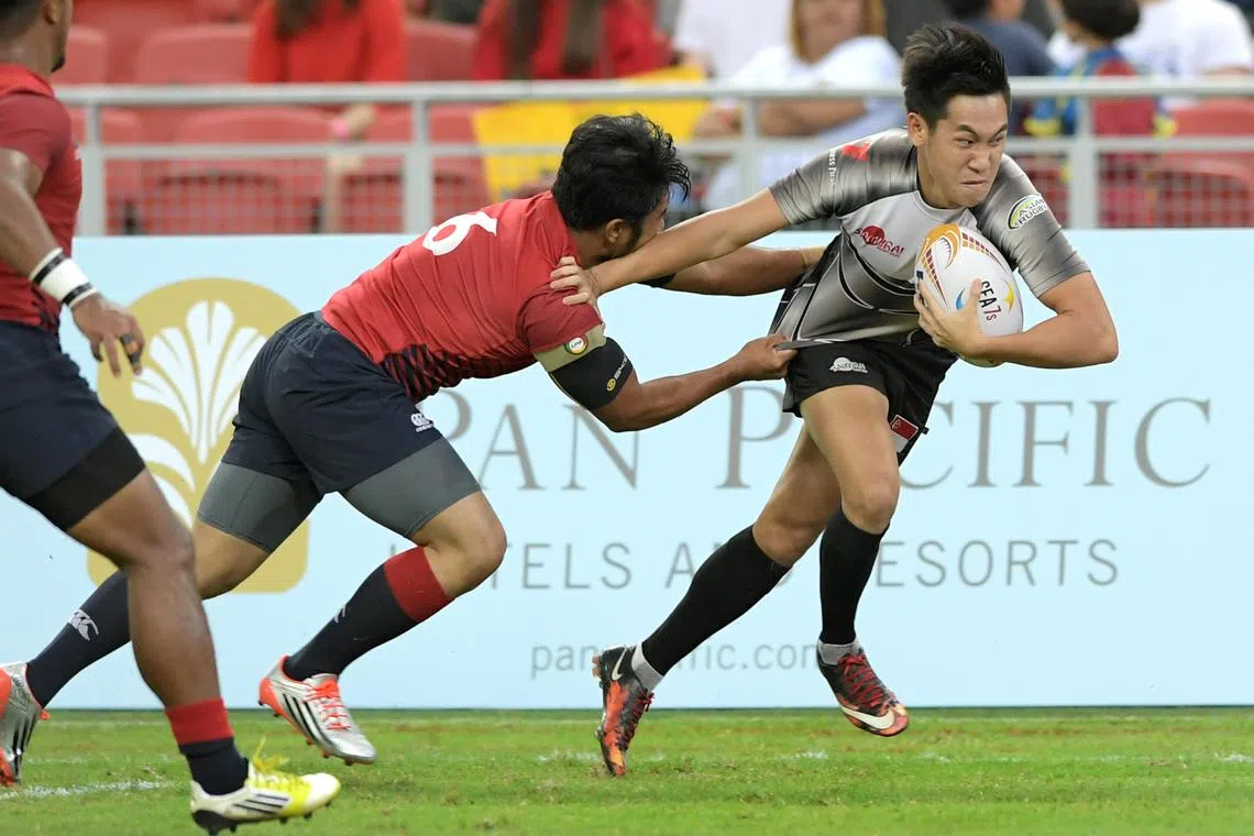 Singapore's Mattias Chia brushing aside his Malaysian opponent to score a try in a 19-7 win to clinch the host nation’s first SEA Sevens trophy in 2017. The event will return here next week.