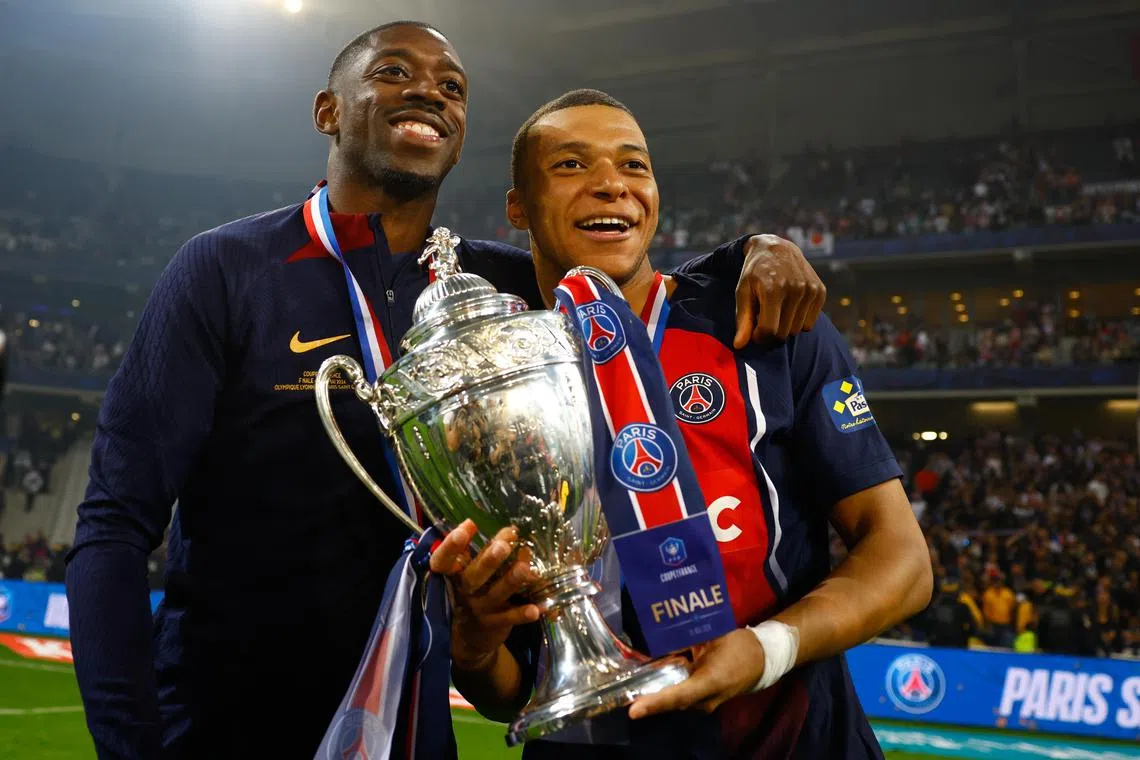 Paris Saint-Germain star Kylian Mbappe celebrates with teammate Ousmane Dembele after winning the French Cup on May 25, 2024.