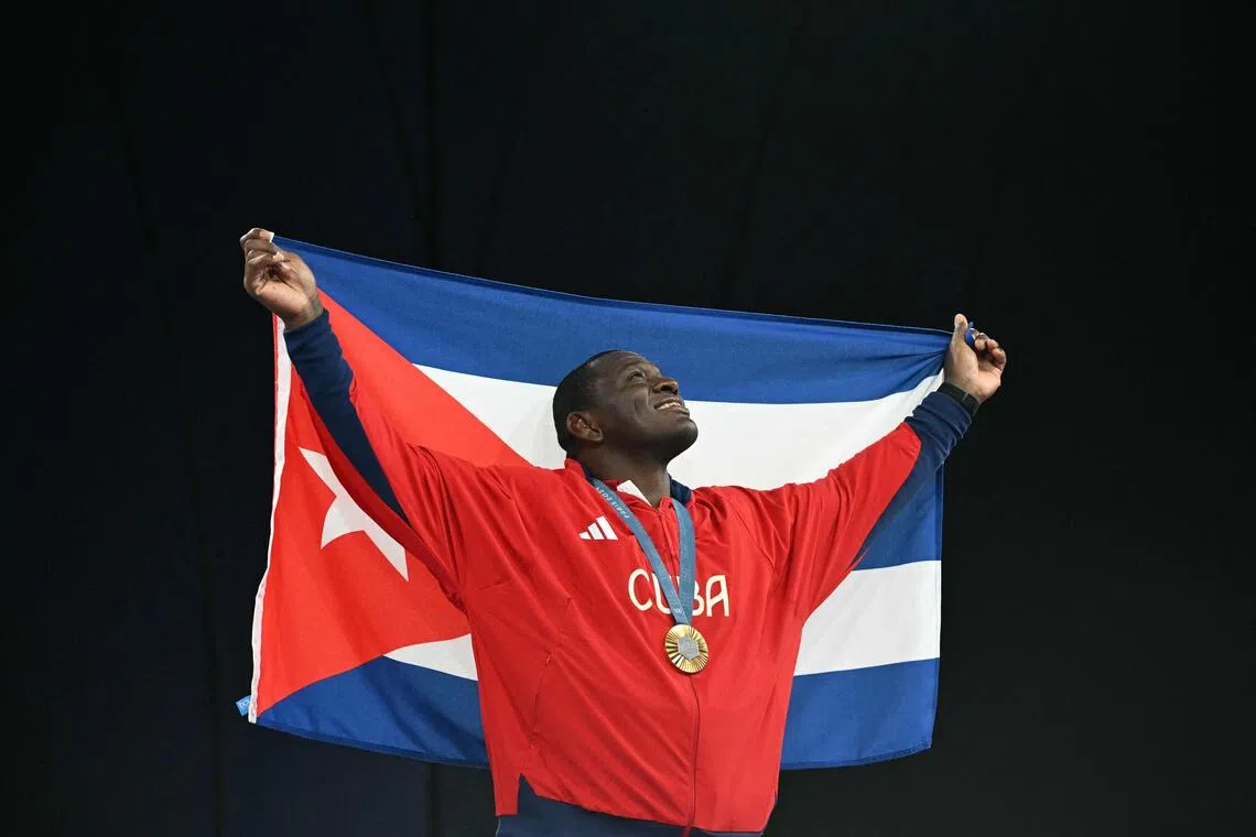Cuba's Mijain Lopez Nunez poses with the Cuban flag and his gold medal during the Paris 2024 Olympic Games.