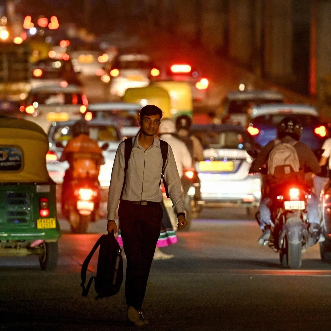An office-goer walks along a road near the Manyata Tech Park in Bengaluru on September 22, 2025. PHOTO: AFP