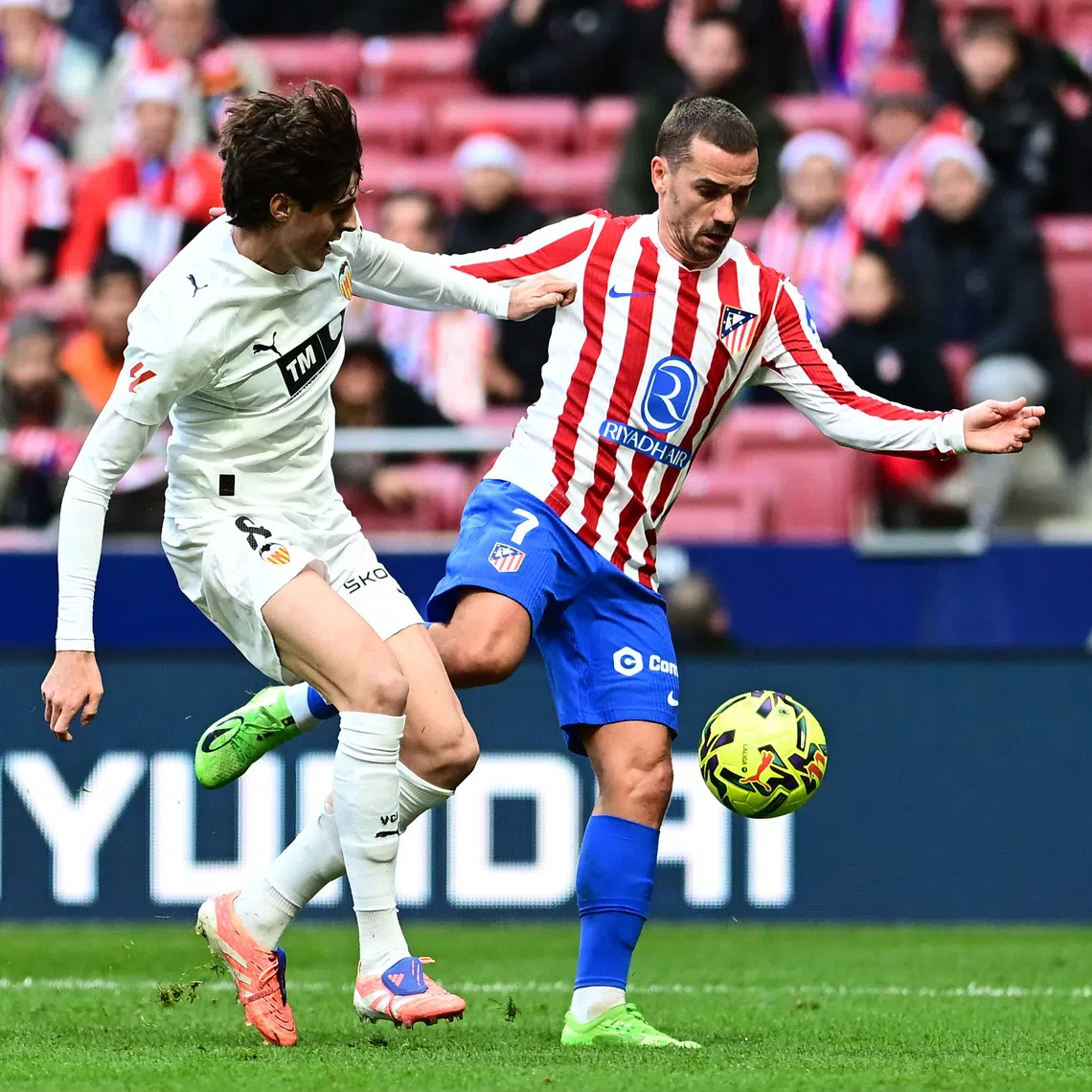 Soccer Football - LaLiga - Atletico Madrid v Valencia - Riyadh Air Metropolitano, Madrid, Spain - December 13, 2025 Atletico Madrid's Antoine Griezmann in action with Valencia's Javi Guerra REUTERS/Juan Barbosa
