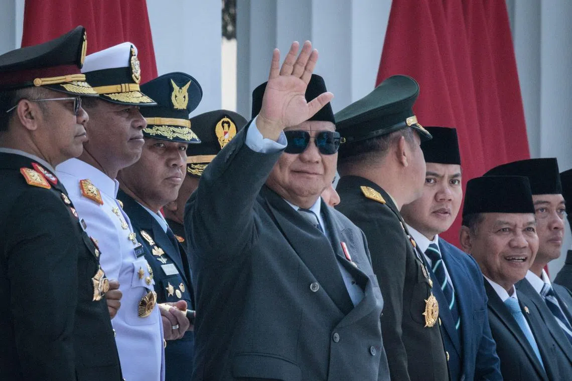 Indonesian President Prabowo Subianto (C) waves during a commissioning ceremony for around 2,000 graduates from military and police academies at the Presidential Palace in Jakarta on July 23, 2025. (Photo by YASUYOSHI CHIBA / AFP)